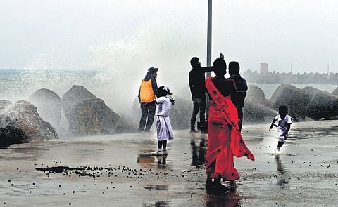 People enjoying the cool weather at Kasimedu harbour in Chennai, as the waves  crash against the groyne on Monday 
