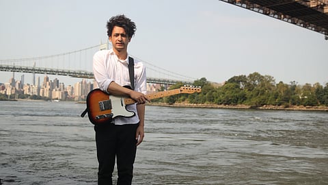 With a guitar on his back