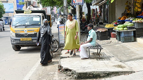 A man waits in a roofless bus shelter at Kura Theru in Woraiyur.