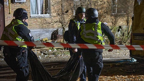 Policers carry the body of a civilian who was killed as a drone hit a residential building during Russia's night missile and drone attack in Kyiv, Ukraine, Saturday, Nov. 29, 2025. 