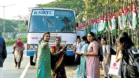 Passengers wait for another ride after the  KSRTC bus they were travelling in broke down at Nettoor Junction.