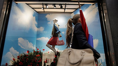  A woman walks past the Gucci store window at the Via Montenapoleone fashion district during Milan's fashion week in Milan, Italy, Sept. 25, 2020.