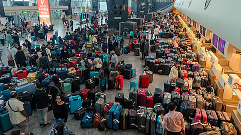 Stranded passengers search for their luggage near a counter after IndiGo cancelled more than 400 flights, at the Kempegowda International Airport, in Bengaluru, Karnataka, Friday, December 5, 2025. 