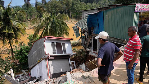 People look at a building damaged by the floods in Peradeniya, Sri Lanka, Monday, Dec. 1,2025