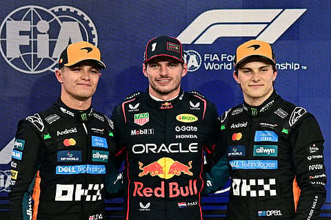 (From L-R) McLaren's British driver Lando Norris. Red Bull Racing's Dutch driver Max Verstappen, and McLaren's Australian driver Oscar Piastri pose for a picture after the qualifying session ahead of the Abu Dhabi Formula One Grand Prix.