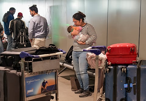 A passenger looks after a newborn baby as she waits at Terminal 1 (T1) of the Indira Gandhi International Airport, in New Delhi, Saturday, Dec. 6, 2025. 