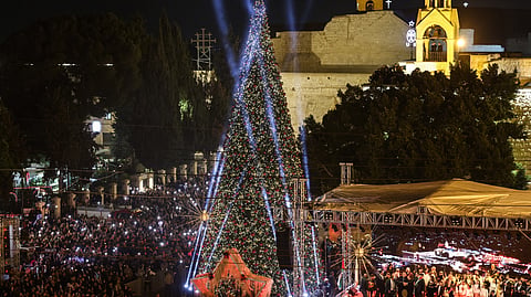 Spectators gather on Nativity Square during a Christmas tree lighting ceremony in Bethlehem, in the Israeli-occupied West Bank, on December 6