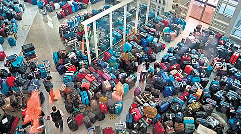 Passengers looking for their bags in the massive buildup of unclaimed luggage at IGI Airport on Sunday, December 7, 2025.