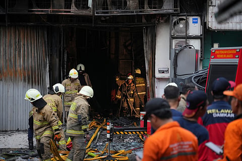 Firefighters work in an office building that caught fire in Jakarta, Indonesia, Tuesday, Dec. 9, 2025. 
