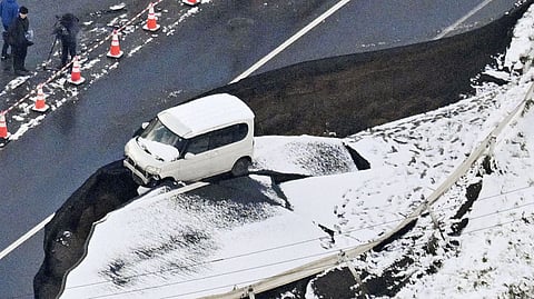 This aerial photo shows a vehicle sitting on a damaged road in Tohoku town, Aomori prefecture, northern Japan Tuesday, Dec. 9, 2025, following a powerful earthquake on late Monday. 