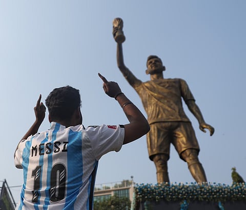 Foul?: A fan wearing No. 10 jersey gestures in front of the statue of football legend Lionel Messi at Kolkatal on Saturday, Dec 13, 2025.