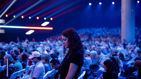 An attendee prays during Turning Point USA's AmericaFest 2025, Thursday, Dec. 18, 2025, in Phoenix. 