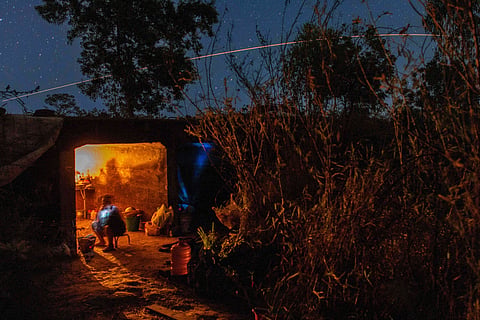 Thai resident cooks in a shelter while Thai military fires artillery towards Cambodia, Saturday, Dec. 20, 2025, in Surin province, Thailand.