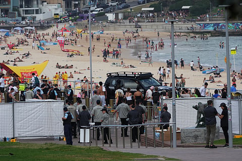 Security officers gather near a gate at Bondi Beach in Sydney, Sunday, Dec. 21, 2025, ahead of a ceremony to mark the National Day of Reflection for victims and survivors from the Bondi shooting on December 14. 
