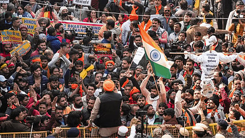  Vishwa Hindu Parishad (VHP) and Bajrang Dal members wave the national flag during a protest outside the Bangladesh High Commission over attacks on Hindus in the neighbouring country, in New Delhi, Tuesday, Dec. 23, 2025