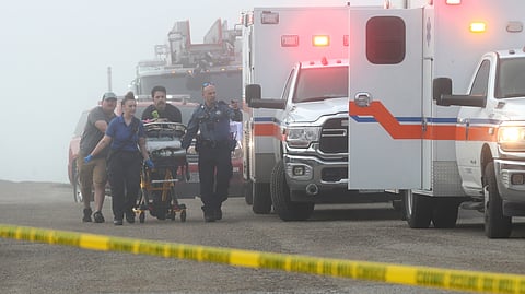 Emergency personnel rush a victim of a small plane crash to an awaiting ambulance, Monday, Dec. 22, 2025, near the Galveston causeway, near Galveston, Texas.