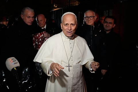 Pope Leo XIV talks to journalists as he leaves the Castel Gandolfo  residence to head the Vatican, Tuesday, Dec 23, 2025.