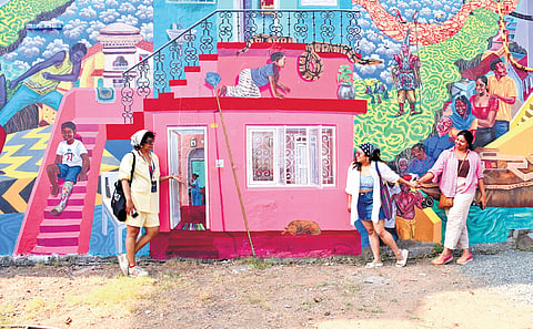 Actor Rima Kallingal, along with her friends, views a massive mural created by the eight-member artists’ collective ‘Trespassers’ at Cube Art Space on Mattancherry Bazaar Road, as part of the Kochi-Muziris Biennale 