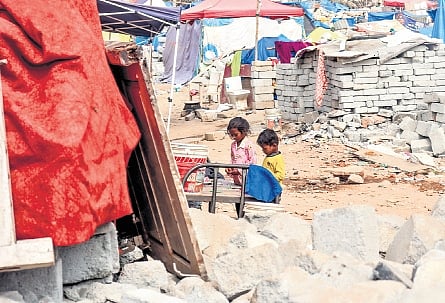 Children play amid the rubble of their houses at Kogilu on Monday 