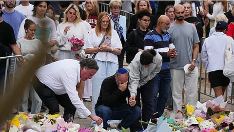 People weep and offer flowers at a floral memorial for victims of Sunday's shooting at the Bondi Pavilion at Bondi Beach on Tuesday, Dec. 16, 2025, in Sydney, Australia.