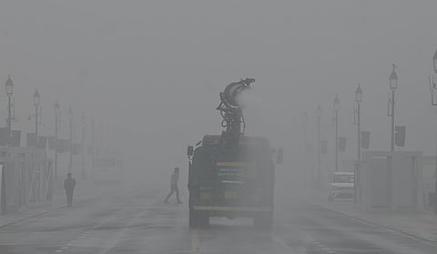 A vehicle sprays water using an anti-smog gun to curb air pollution on a smoggy winter morning in New Delhi. 