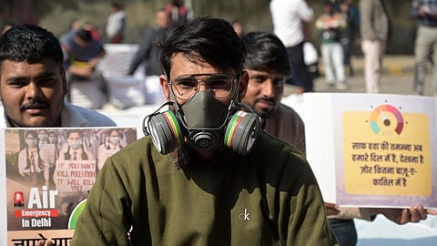 Demonstrator wearing an oxygen mask protests, demanding governments' action to reduce air pollution in New Delhi.