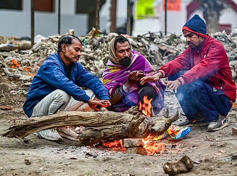People sit around a makeshift fire on a cold winter morning, in Prayagraj, Uttar Pradesh, Sunday, Jan. 4, 2026. 
