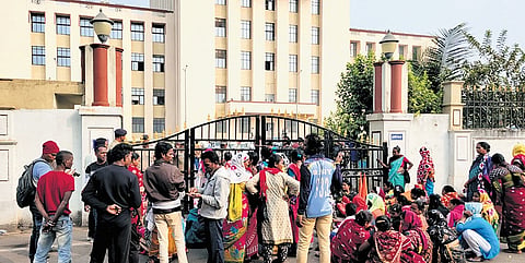 Sanitation workers staging dharna in front of the new BMC office alleging work overload, in Bhubaneswar on Monday.