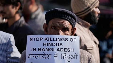 A Congress party supporter holds a placard during a protest alleging that Bangladeshi groups are wrongly targeting Hindus in Bangladesh, in Jammu, India, Wednesday, Dec. 24, 2025.