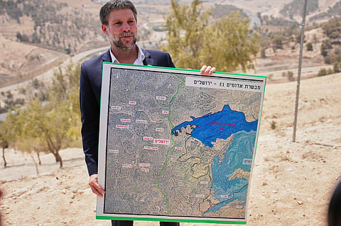  Israeli Finance Minister Bezalel Smotrich holds a map that shows the E1 settlement project during a press conference near the settlement of Maale Adumim, in the Israeli-occupied West Bank, Aug. 14, 2025.