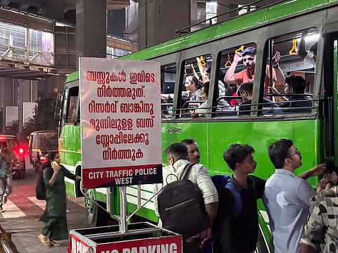 A private bus picking up passengers in front of Town Hall metro station