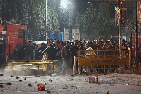 Protesters pelt stones after violence erupts during the demolition drive of alleged encroachments near the Syed Faiz Elahi mosque at the Turkman Gate area by the Municipal Corporation of Delhi (MCD), in New Delhi on Tuesday.