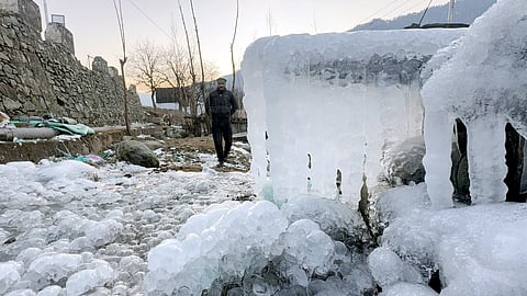 A man walks past icicles hanging from a structure amid heavy frost and snow cover during a cold wave in the valley, in Anantnag district, Jammu and Kashmir, Friday, Jan. 9, 2026.