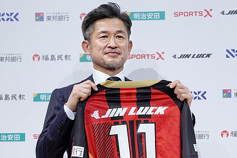Japanese soccer player Kazuyoshi Miura poses with uniform of third-division J-League team Fukushima United. during a press conference in Tokyo, Japan, on Jan. 9, 2026.