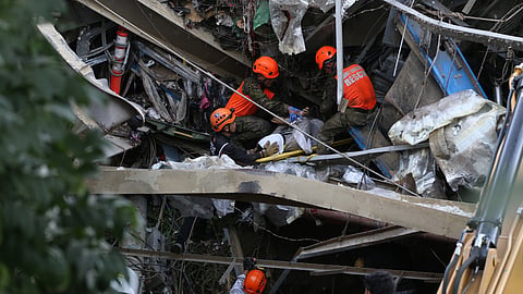 Rescuers retrieve a body inside a collapsed waste segregation facility in Binaliw, Cebu city, central Philippines on Friday, Jan. 9, 2026.