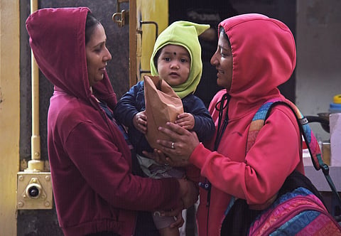  Women and child seen with warm sweater and caps , IMD as  forecast cold wave conditions over most parts of interior Karnataka, some parts of Bengaluru on Saturday  in Bengaluru.
