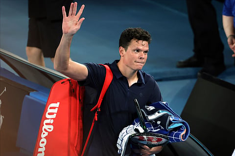 Milos Raonic of Canada waves as he leaves Rod Laver Arena after retiring from his first round match against Alex de Minaur of Australia at the Australian Open tennis championships.