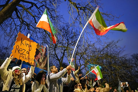 Protesters hold up placards and flags as they demonstrate outside the Iranian Embassy in London, Monday, Jan. 12, 2026. (AP Photo/Alastair Grant)