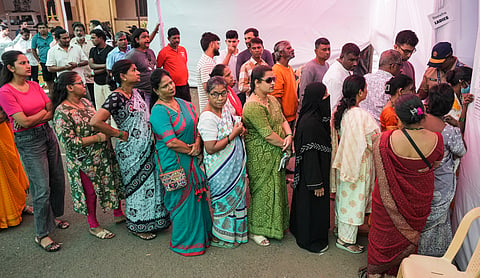People wait in queues outside a polling booth before casting their votes in the civic polls, in Mumbai, Thursday, Jan. 15, 2026. 