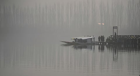 Boatmen wait for tourists near their parked boats through dense fog on a cold day at Dal Lake in Srinagar, Indian controlled Kashmir, Wednesday, Dec. 3, 2025.