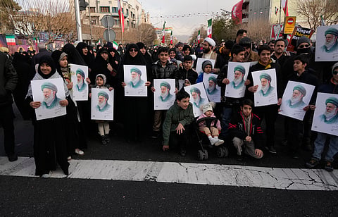 People hold posters of the Iranian Supreme Leader Ayatollah Ali Khamenei during a funeral ceremony for a group of security forces, who were killed during anti-government protests, in Tehran, Iran,  Jan. 14, 2026. 