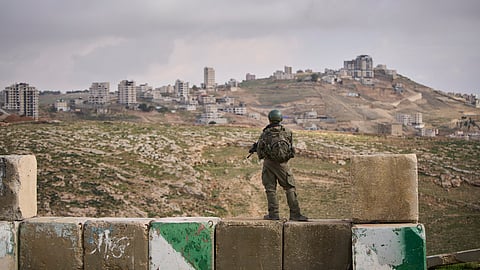 An Israeli soldier stands guard during the inauguration ceremony for an illegal Jewish settlement of Yatziv, near the Palestinian town of Beit Sahour, in the West Bank, Jan. 19, 2026. 