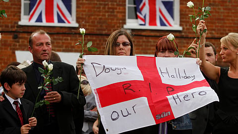 Relatives of British Army Private Douglas Halliday, of the 1st Battalion The Mercian Regiment, one of the seven British soldiers killed in Afghanistan, line a street as his coffin is driven through the town of Wootton Bassett, England, following repatriation, Tuesday, June 29, 2010. 