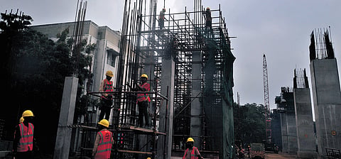 Labourers busy working at the Chennai Metro Rail Limited construction site  in 
St Thomas Mount under a blanket of dark clouds on Friday.