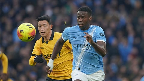 Manchester City's Marc Guehi, right, vies for the ball with Wolverhampton Wanderers' Hwang Hee-chan, during the EPL soccer match between Manchester City and Wolverhampton Wanderers on Jan. 24, 2026. 