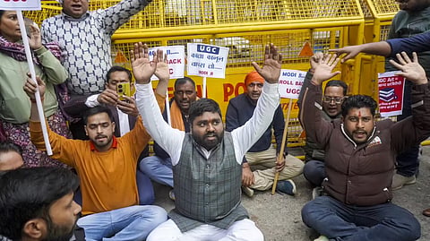 Demonstrators oppose the new UGC regulations amid rain.