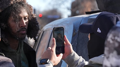  Federal agents use a facial recognition app on a person detained and who later released on Tuesday, Jan. 27, 2026, in Minneapolis.