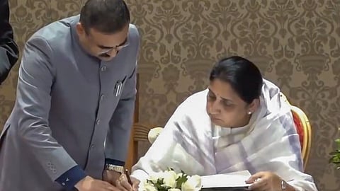 Rajya Sabha MP Sunetra Pawar, wife of late NCP chief Ajit Pawar, signs documents after taking oath as Maharashtras first woman Deputy Chief Minister during a ceremony at Lok Bhavan, in Mumbai. 