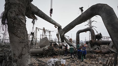 Workers clean up damage at Darnytsia Thermal Power Plant after a Russian attack in Kyiv, Ukraine, Wednesday, Feb. 4, 2026. 