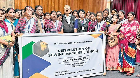 Hrushikesh Mishra poses with members of a women’s group after donating 25 sewing machines to them.